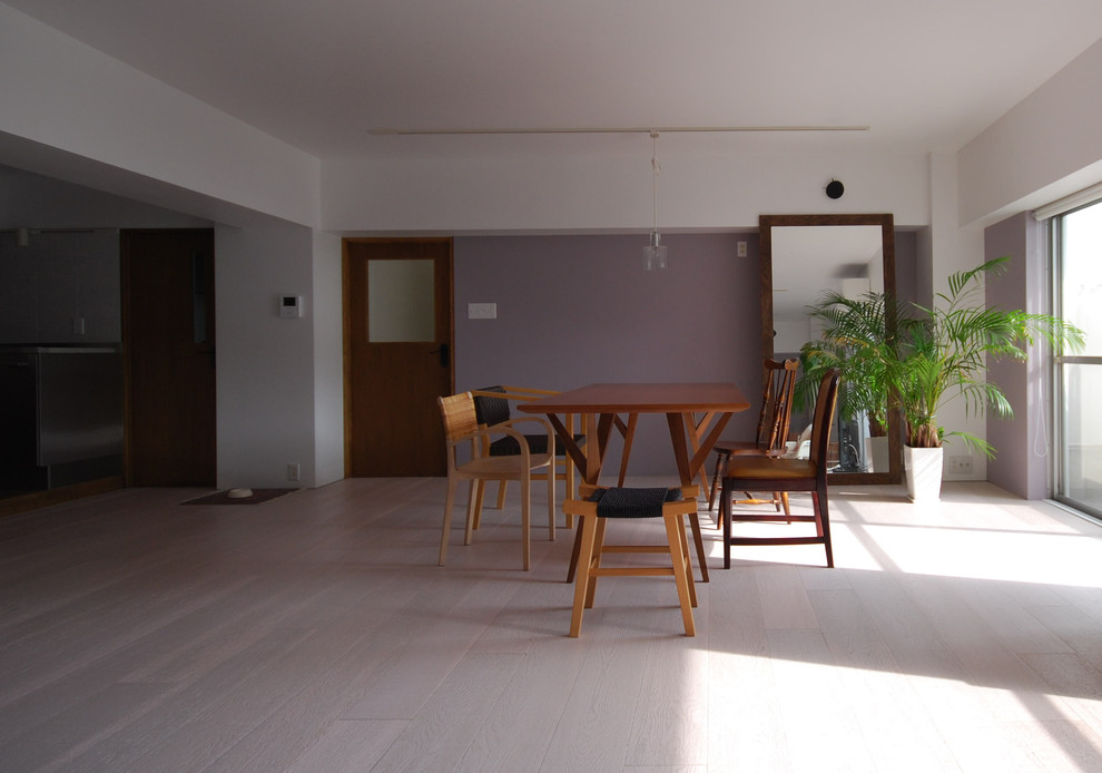 Cette image montre une salle à manger ouverte sur le salon design avec un mur violet, un sol en contreplaqué et un sol blanc.