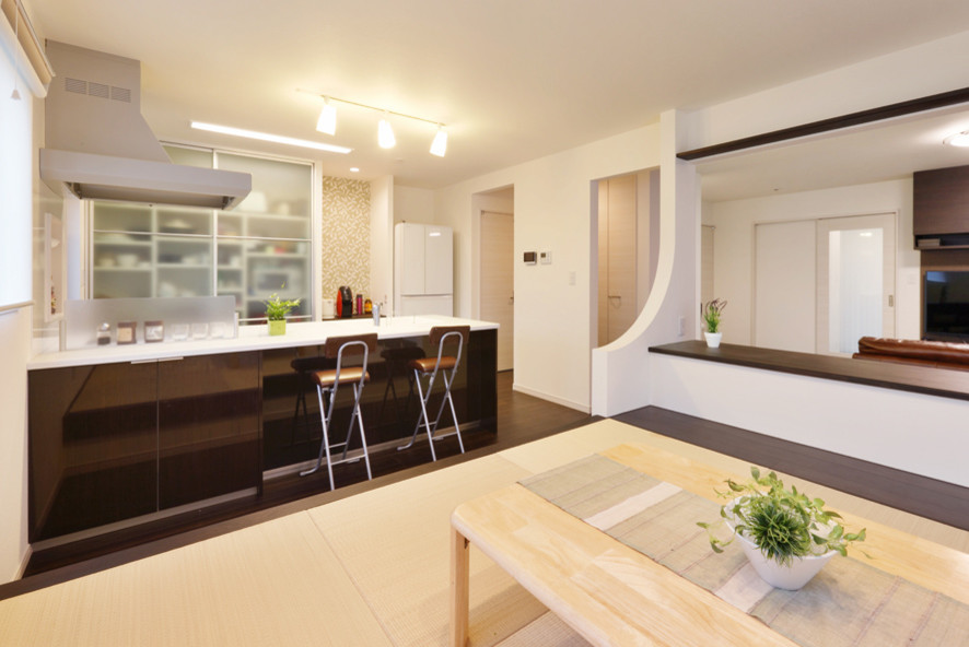 На фото: гостиная-столовая среднего размера в стиле модернизм с белыми стенами, полом из фанеры и коричневым полом