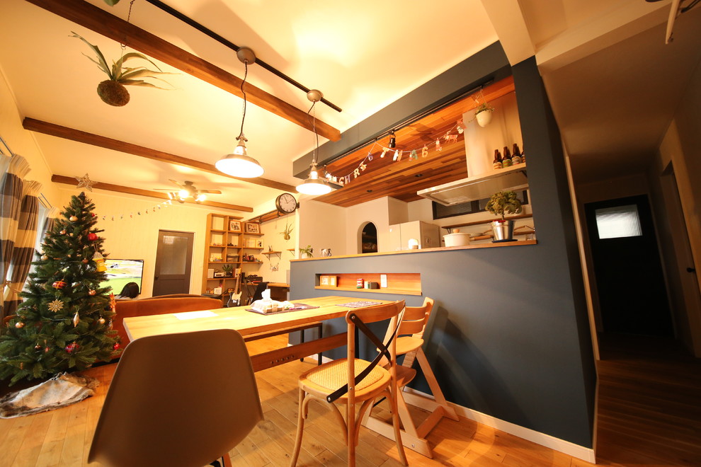 Immagine di una sala da pranzo aperta verso il soggiorno stile marinaro con pareti blu