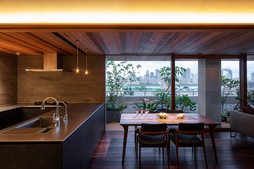 Offenes Modernes Esszimmer mit grauer Wandfarbe, dunklem Holzboden und braunem Boden in Osaka