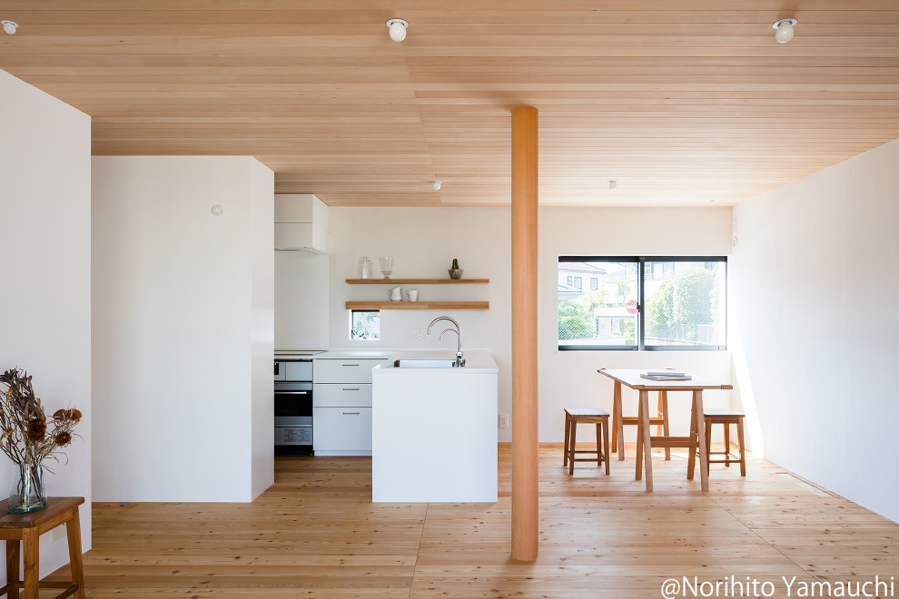 Cette photo montre une salle à manger ouverte sur le salon moderne avec un mur blanc, un sol en bois brun, un plafond en bois et du lambris de bois.