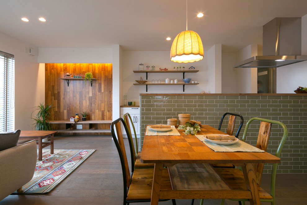 Inspiration pour une salle à manger ouverte sur le salon nordique avec un mur blanc, un sol marron, aucune cheminée et un sol en bois brun.