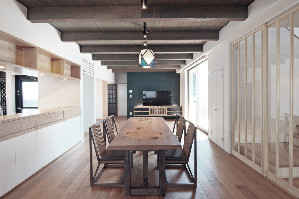 Ispirazione per una sala da pranzo aperta verso il soggiorno minimal con pareti bianche, pavimento in legno massello medio e nessun camino