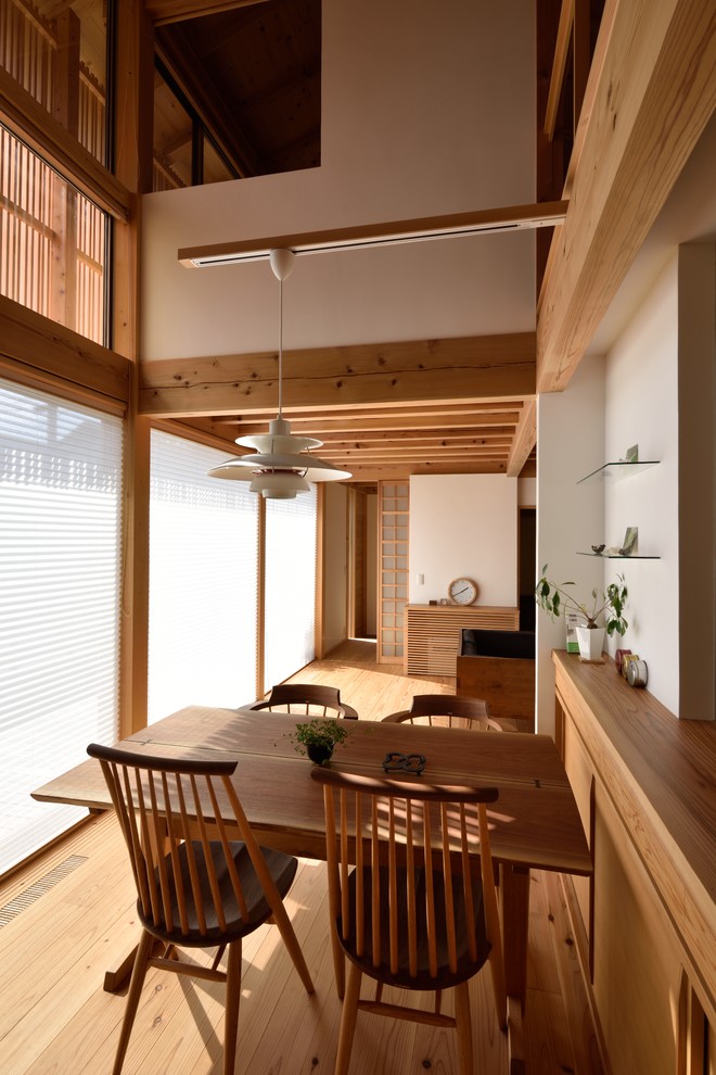Inspiration for a medium tone wood floor dining room remodel in Tokyo with beige walls and no fireplace