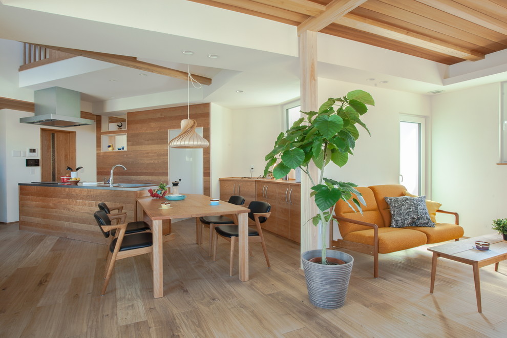 Esempio di una sala da pranzo aperta verso il soggiorno etnica con pareti bianche, pavimento in legno verniciato e pavimento marrone