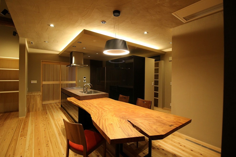 Example of a zen medium tone wood floor and brown floor dining room design in Other with brown walls