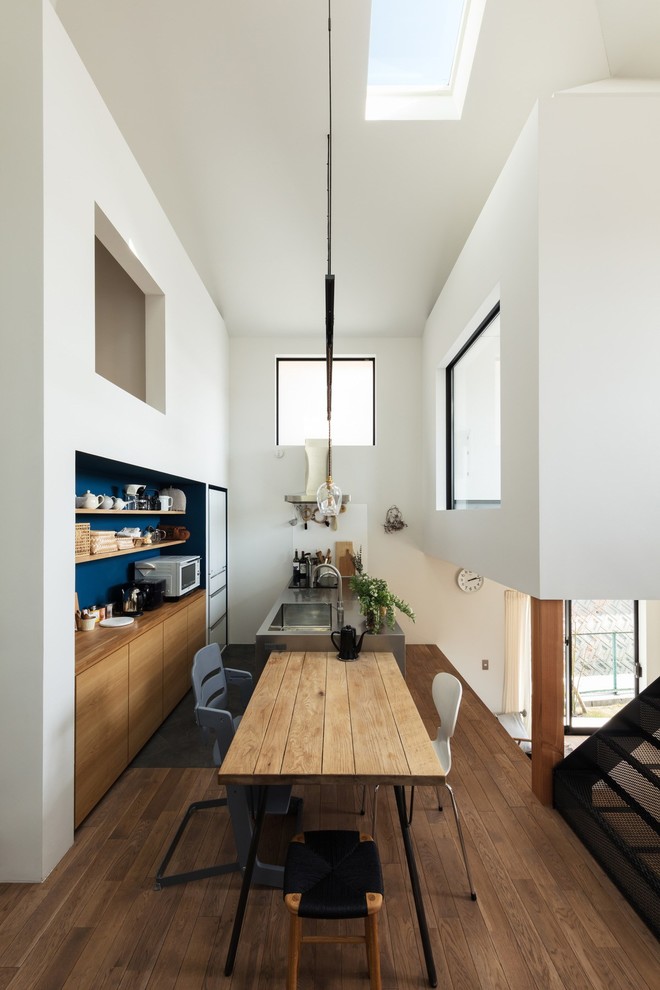 Источник вдохновения для домашнего уюта: гостиная-столовая среднего размера в стиле модернизм с белыми стенами, паркетным полом среднего тона и коричневым полом без камина