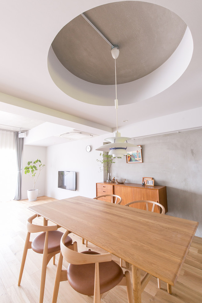 Foto di una sala da pranzo industriale con pareti grigie, parquet chiaro e pavimento marrone