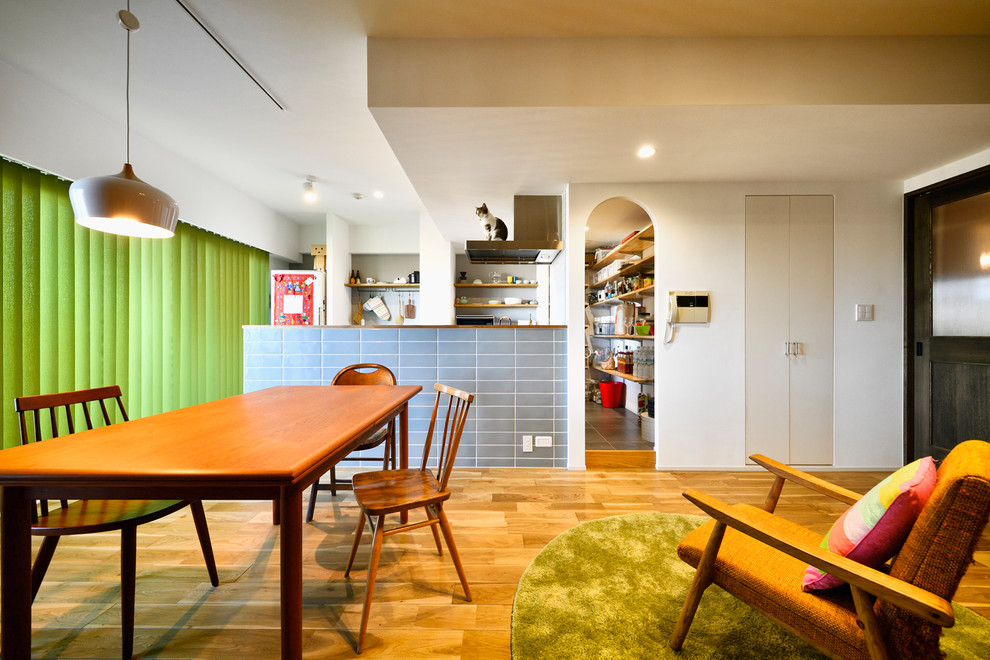 Inspiration för asiatiska matplatser med öppen planlösning, med vita väggar, mellanmörkt trägolv och beiget golv