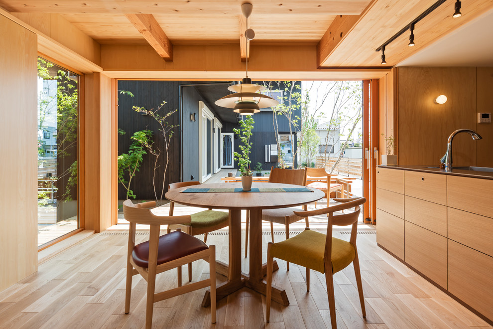 Cette photo montre une salle à manger ouverte sur le salon asiatique avec un mur marron, un sol en bois brun et un sol marron.