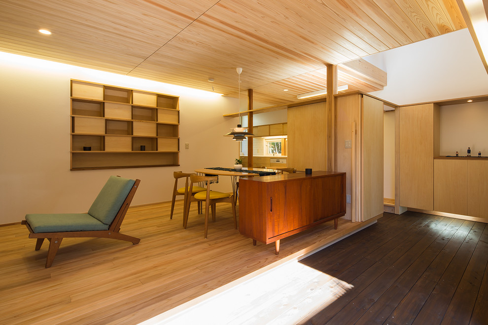 На фото: гостиная-столовая в восточном стиле с белыми стенами, светлым паркетным полом и коричневым полом