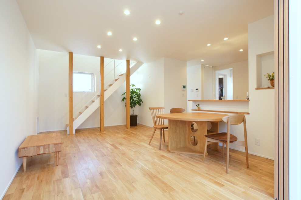 Idées déco pour une salle à manger moderne de taille moyenne avec un mur blanc, parquet clair et un sol beige.