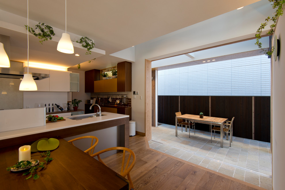 Idée de décoration pour une salle à manger design avec un mur blanc, un sol en bois brun et un sol marron.