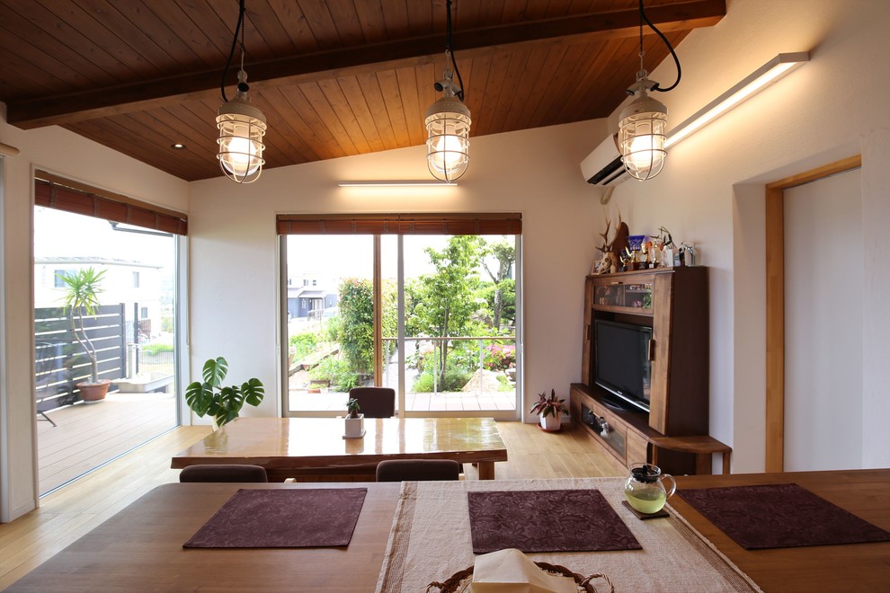 Foto di una sala da pranzo etnica con pareti bianche e pavimento in legno massello medio