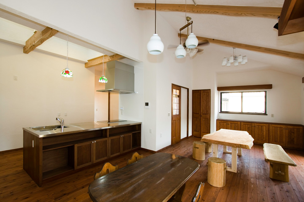 Offenes Asiatisches Esszimmer mit weißer Wandfarbe, braunem Holzboden und braunem Boden in Osaka