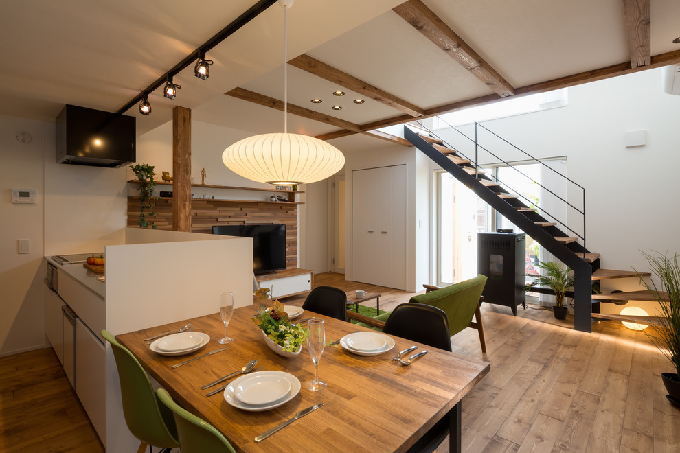 Immagine di una sala da pranzo aperta verso il soggiorno chic con pareti bianche, pavimento in legno massello medio e pavimento marrone
