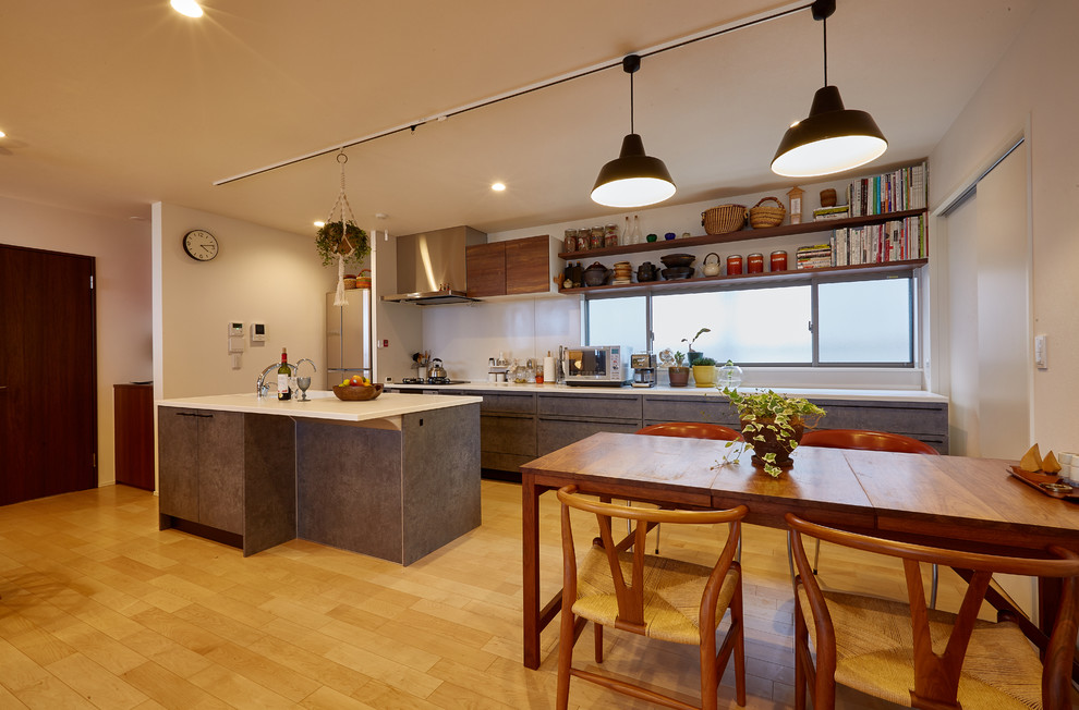 Immagine di una sala da pranzo aperta verso il soggiorno design con parquet chiaro, pavimento beige e pareti bianche