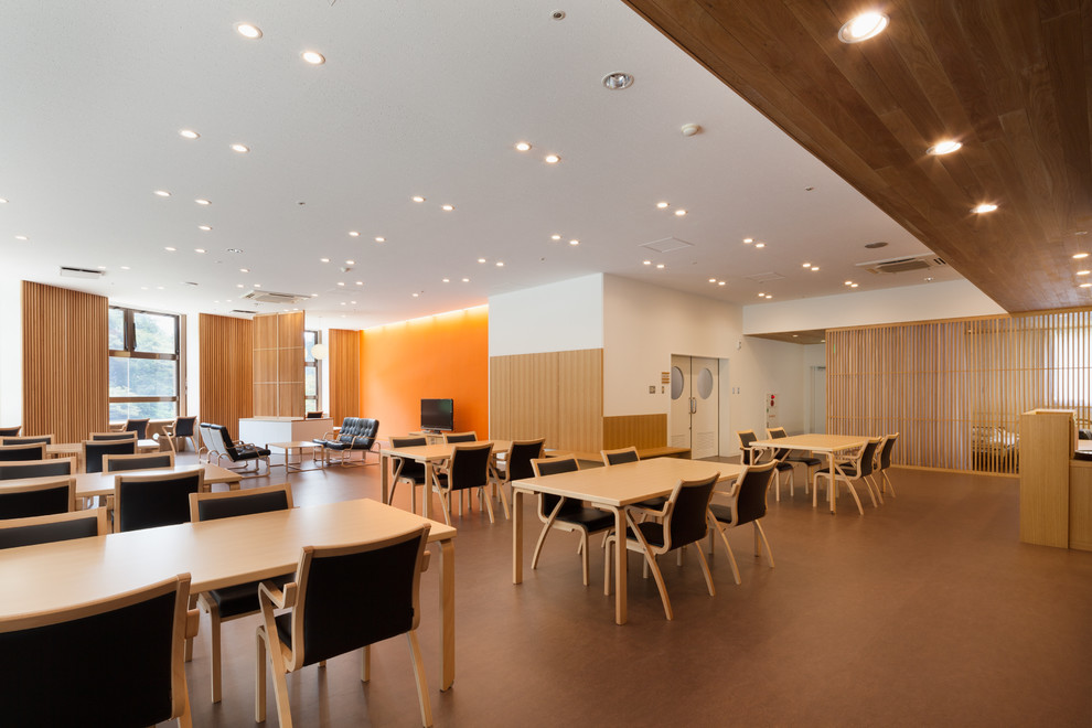 Immagine di una grande sala da pranzo moderna chiusa con pareti marroni, pavimento in linoleum, nessun camino e pavimento marrone