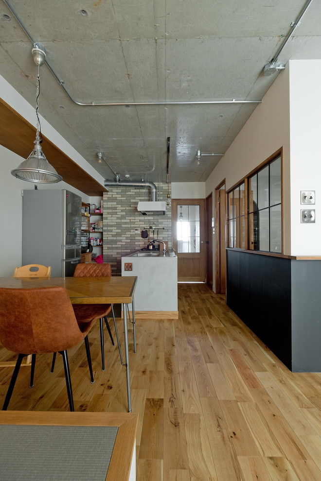 Esempio di una sala da pranzo aperta verso il soggiorno minimalista con pareti bianche, pavimento in legno massello medio, nessun camino e pavimento marrone