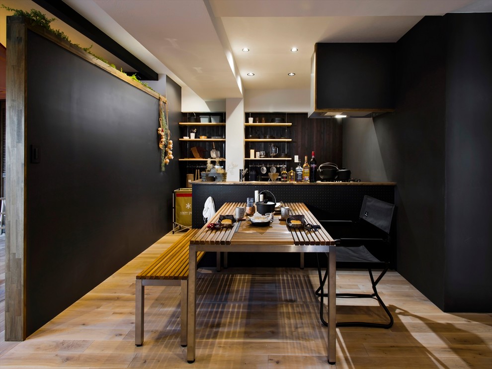 他の地域にあるコンテンポラリースタイルのおしゃれなダイニングキッチン (黒い壁、無垢フローリング、茶色い床) の写真
