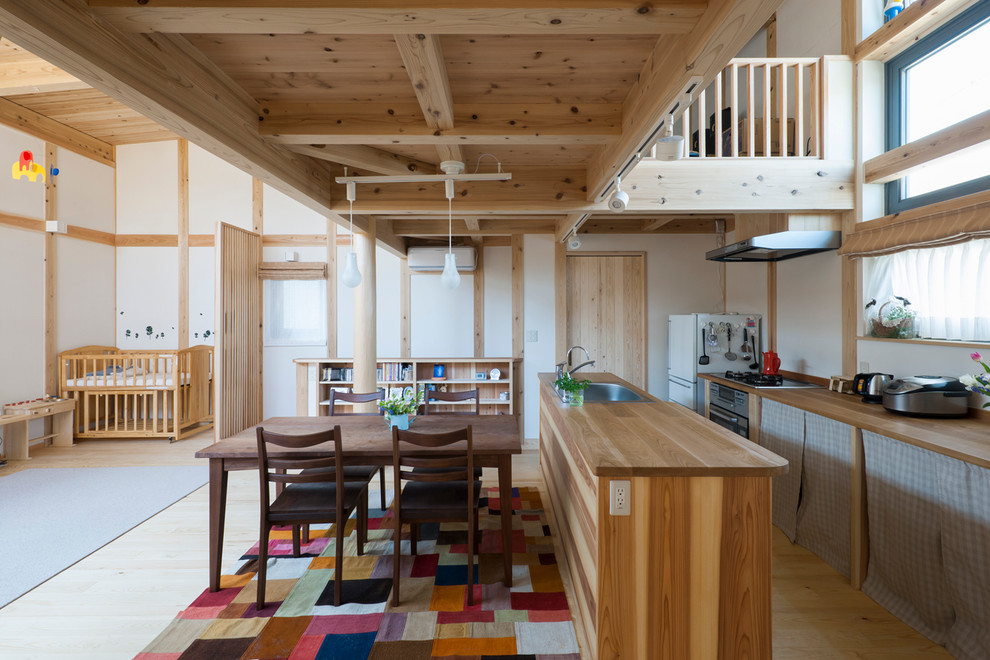 Ejemplo de comedor de estilo de casa de campo de tamaño medio abierto con paredes blancas, suelo de madera clara y suelo beige