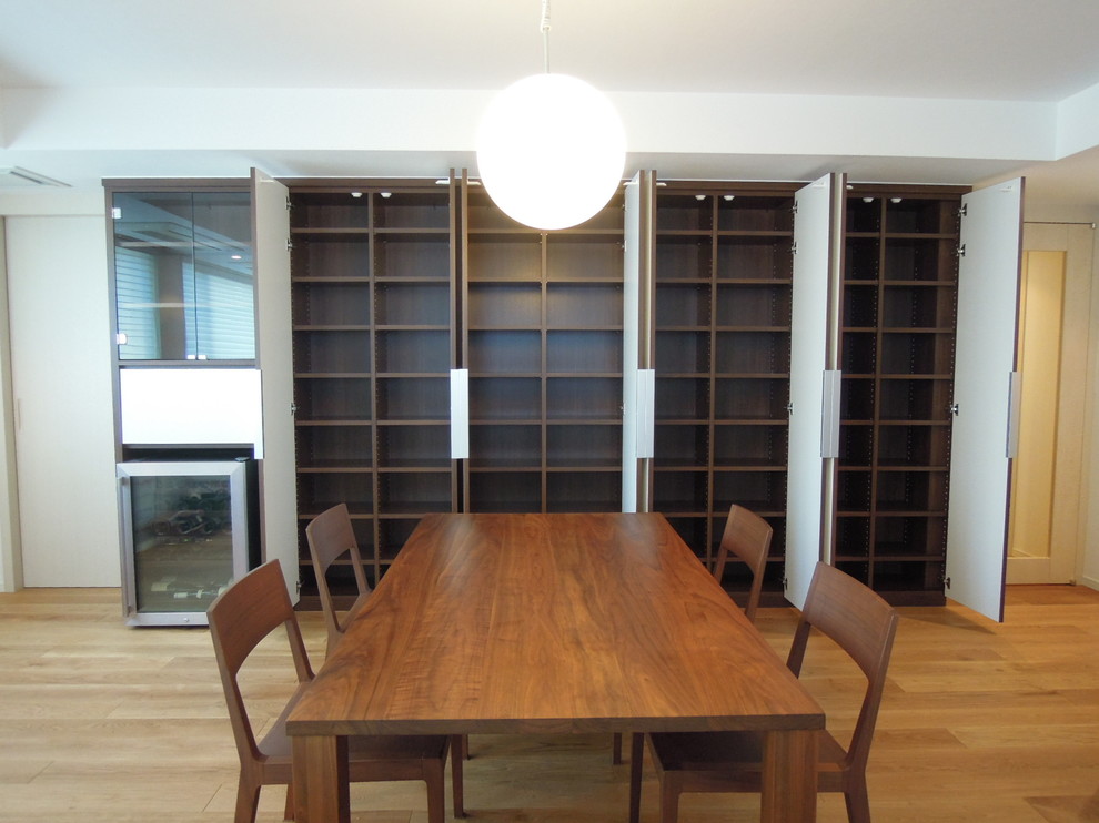 Large modern open plan dining room in Tokyo with white walls, medium hardwood flooring and brown floors.