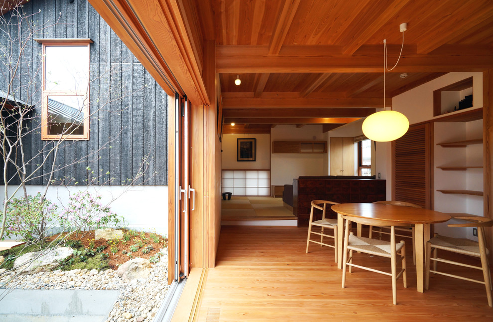 Idee per una sala da pranzo aperta verso il soggiorno etnica con pavimento in legno massello medio