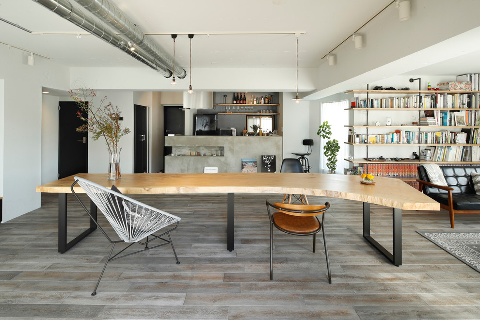Esempio di una sala da pranzo industriale con pareti bianche e pavimento grigio