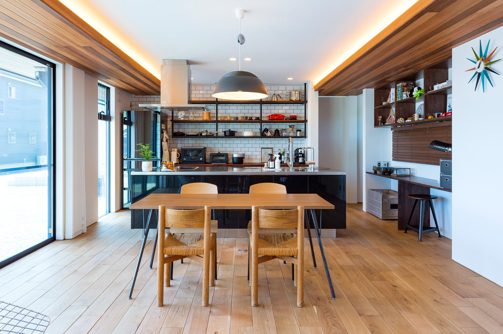 Aménagement d'une salle à manger ouverte sur le salon rétro de taille moyenne avec un mur blanc, parquet clair et un sol marron.