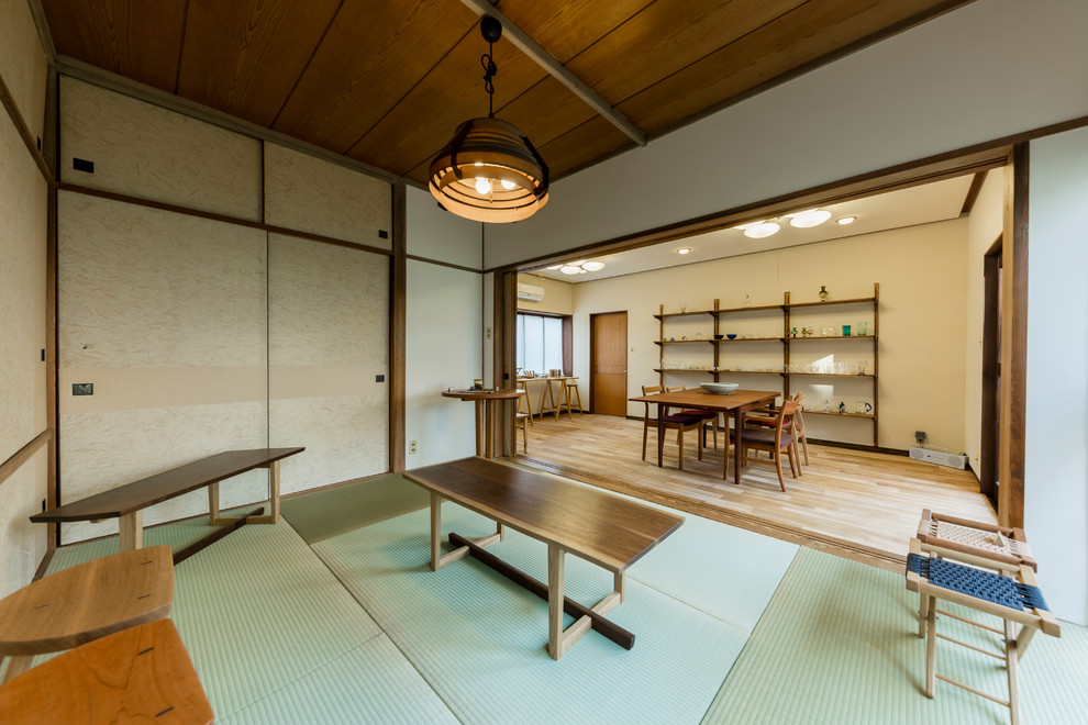Cette photo montre une petite salle à manger asiatique avec un mur blanc, un sol de tatami, aucune cheminée et un sol vert.
