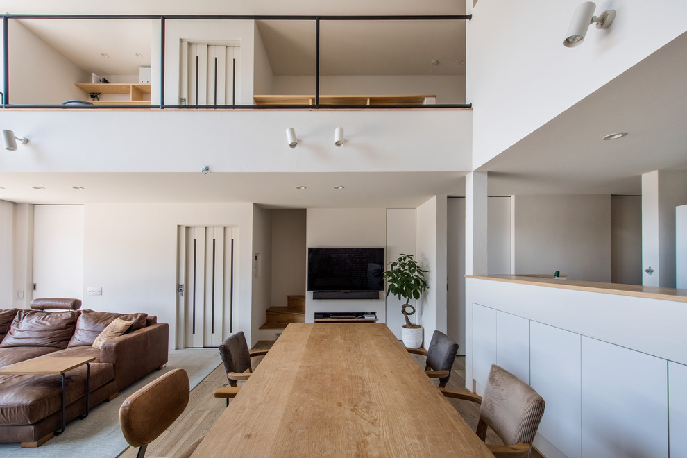 Idee per una sala da pranzo aperta verso il soggiorno industriale di medie dimensioni con pareti bianche, parquet chiaro e pavimento beige
