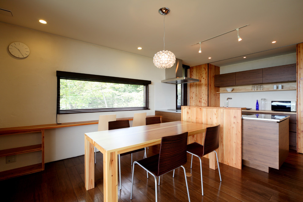 Idées déco pour une salle à manger ouverte sur la cuisine contemporaine de taille moyenne avec un mur blanc, parquet foncé et un sol marron.