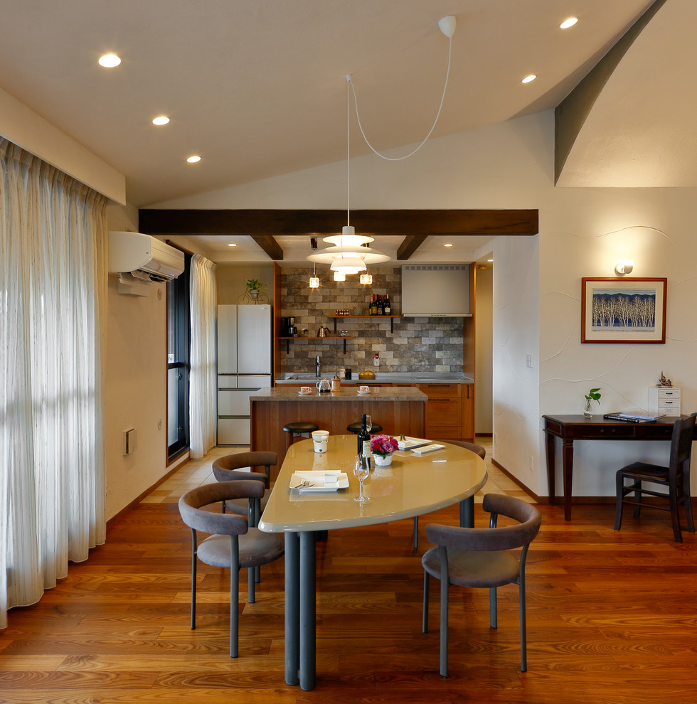 Aménagement d'une salle à manger rétro avec un mur blanc, un sol en bois brun et un sol marron.