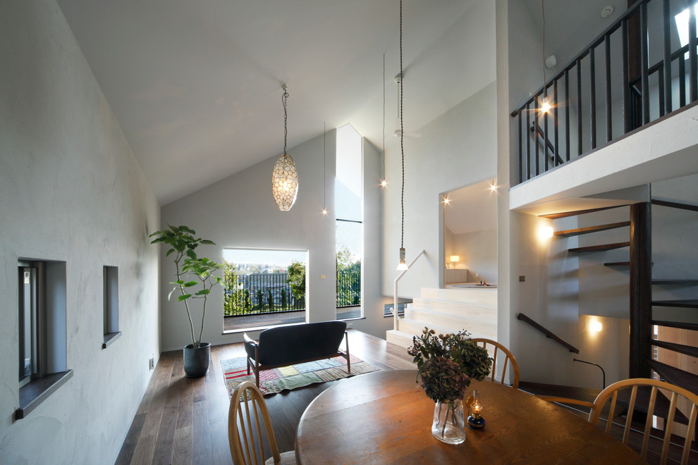 Diseño de comedor escandinavo abierto con paredes blancas y suelo de madera en tonos medios