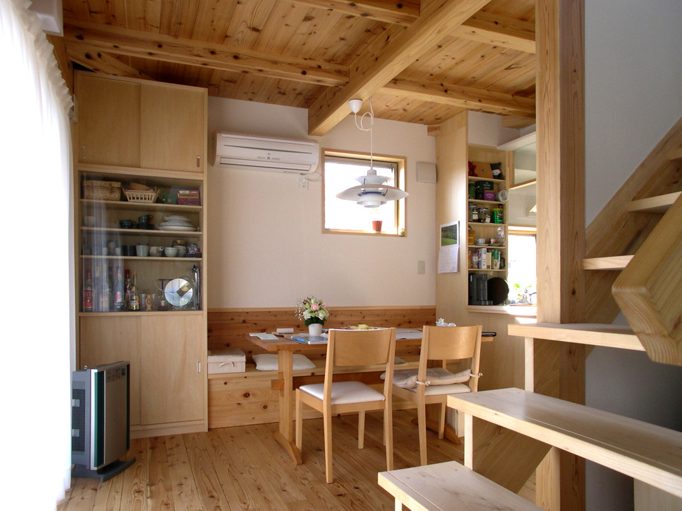 Cette photo montre une salle à manger ouverte sur la cuisine asiatique avec un mur blanc, parquet clair et un sol marron.