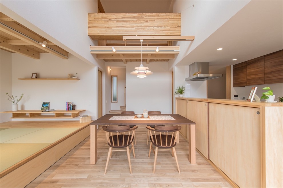 Design ideas for a modern open plan dining room in Yokohama with white walls, light hardwood flooring and beige floors.
