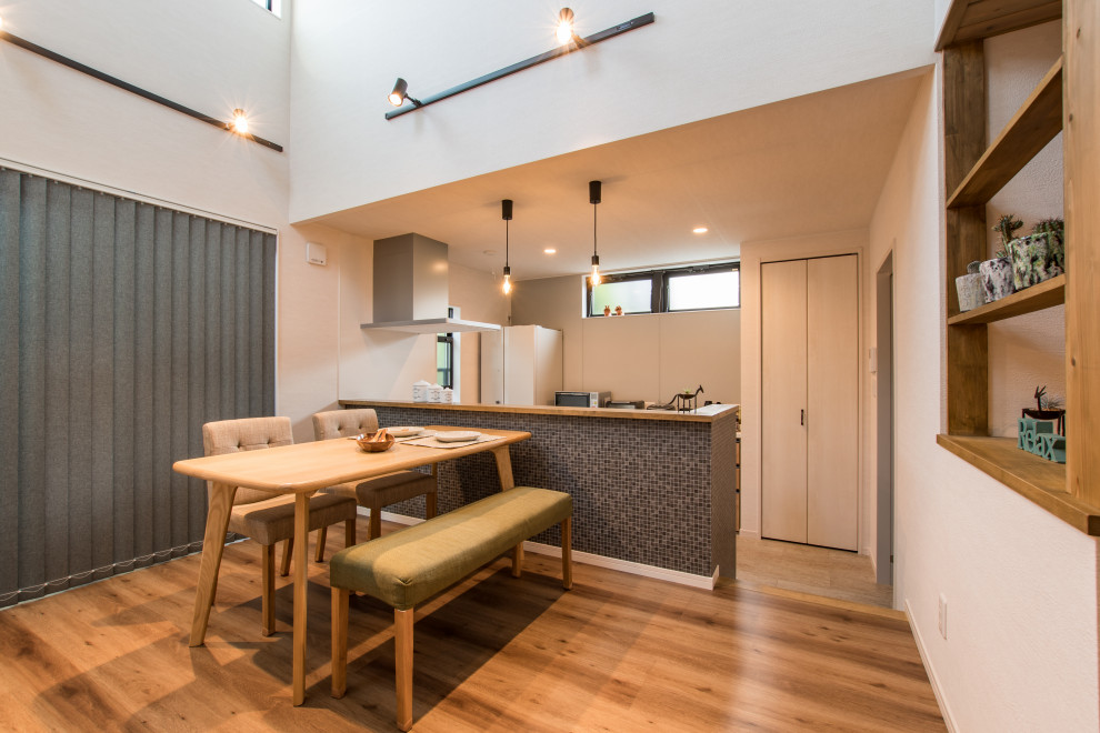 Kleine Nordische Wohnküche ohne Kamin mit weißer Wandfarbe, braunem Holzboden, braunem Boden, Tapetendecke und Tapetenwänden in Sonstige