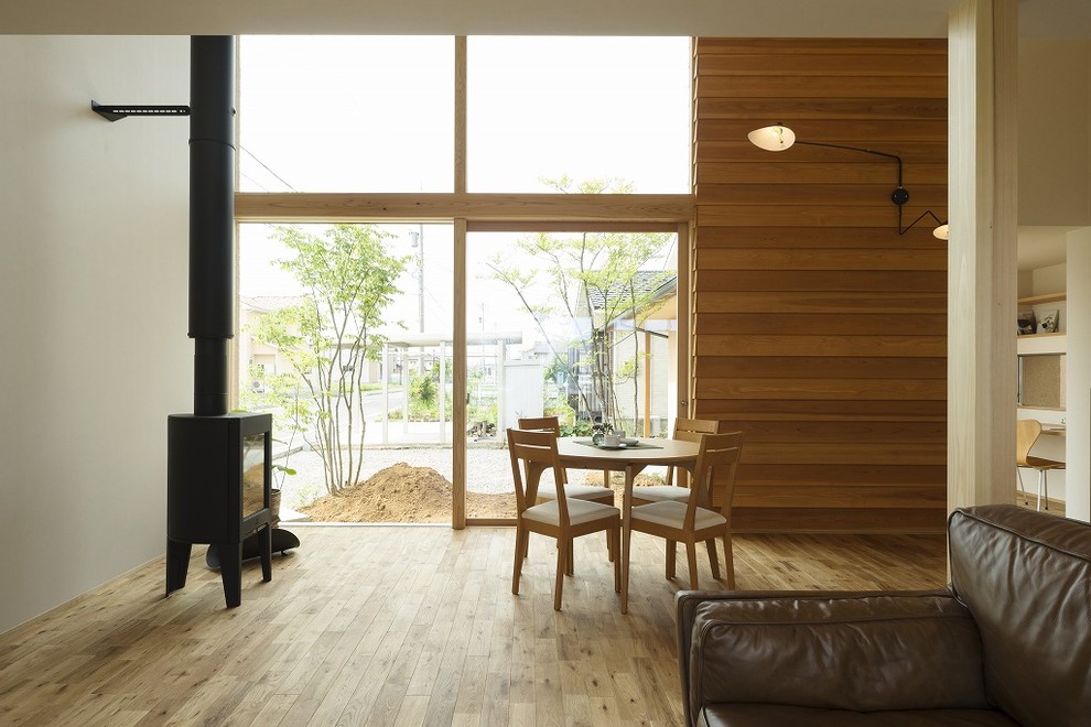 Foto di una sala da pranzo aperta verso il soggiorno etnica con pareti bianche e stufa a legna