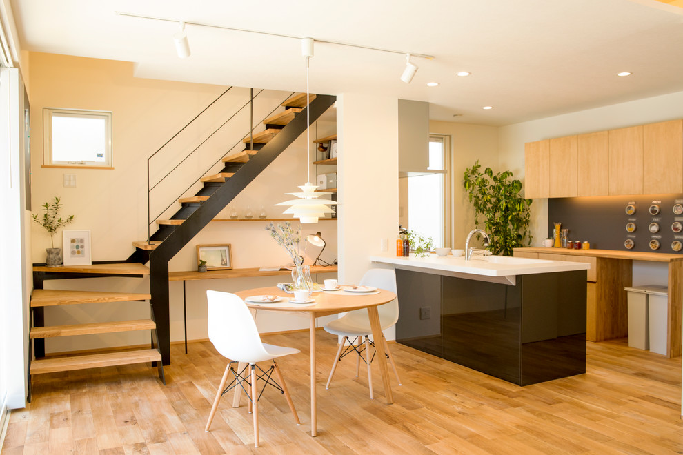 Inspiration pour une salle à manger ouverte sur le salon nordique avec un mur blanc, un sol en bois brun et un sol marron.