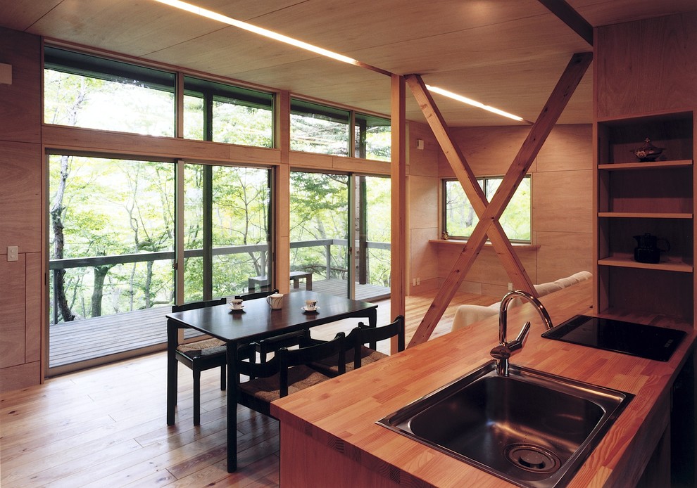 Diseño de comedor contemporáneo pequeño abierto con paredes marrones, suelo de madera clara y suelo marrón