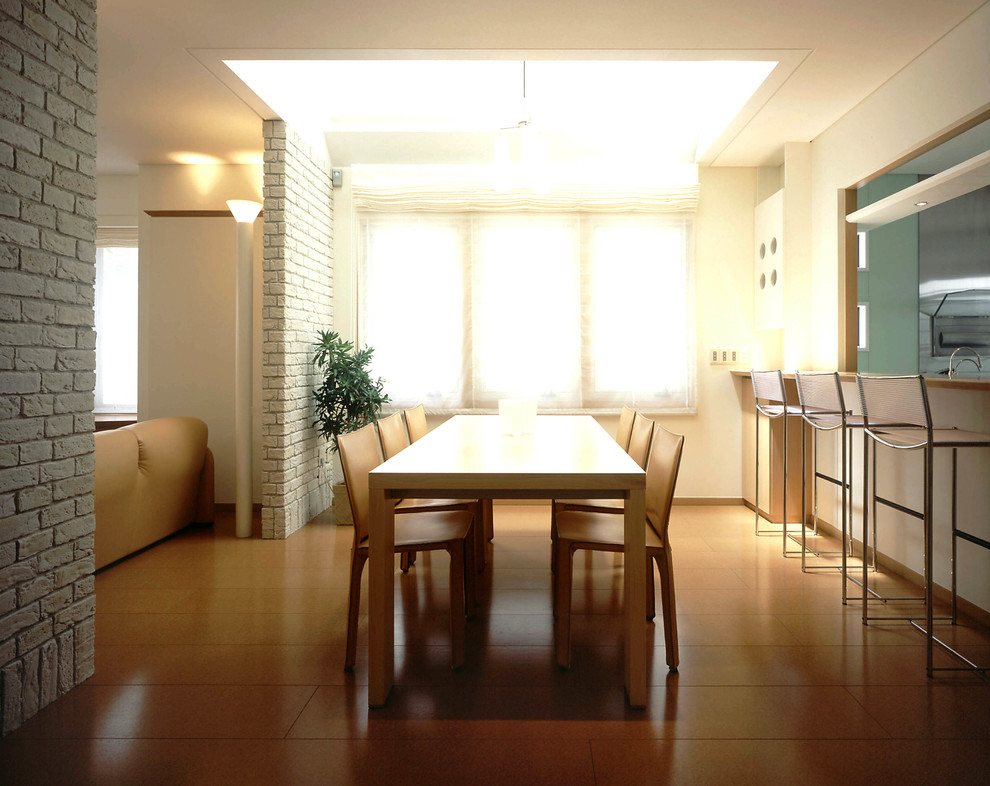 Inspiration pour une salle à manger design avec un mur blanc, un sol en liège et un sol marron.