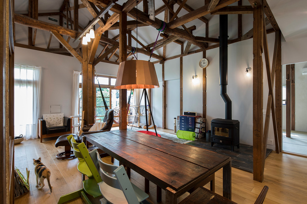 Ispirazione per una sala da pranzo aperta verso il soggiorno stile rurale con pareti bianche, pavimento in legno massello medio e pavimento marrone