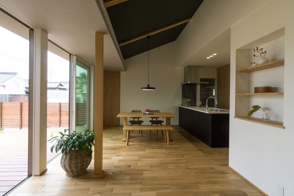 Contemporary open plan dining room in Other with white walls, medium hardwood flooring and brown floors.