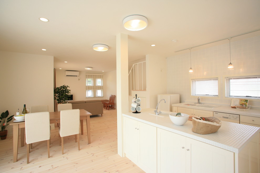 Exemple d'une salle à manger ouverte sur le salon tendance avec un mur beige et parquet clair.