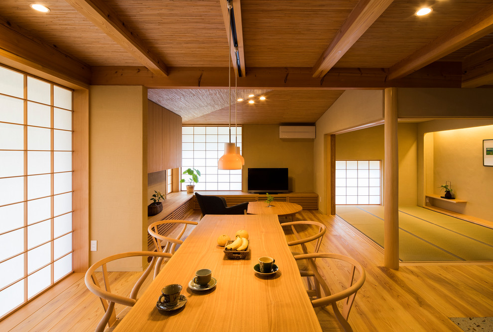Esempio di una sala da pranzo aperta verso il soggiorno etnica con pareti marroni, pavimento in legno massello medio e pavimento marrone