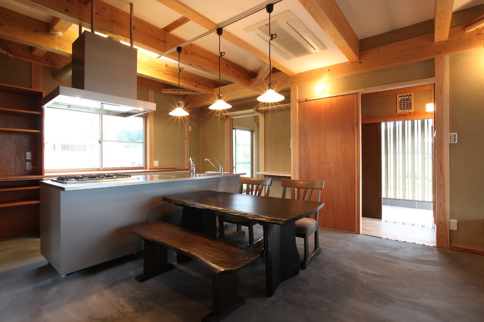 Inspiration pour une salle à manger ouverte sur le salon asiatique de taille moyenne avec un mur marron, sol en béton ciré, un poêle à bois, un manteau de cheminée en carrelage et un sol gris.