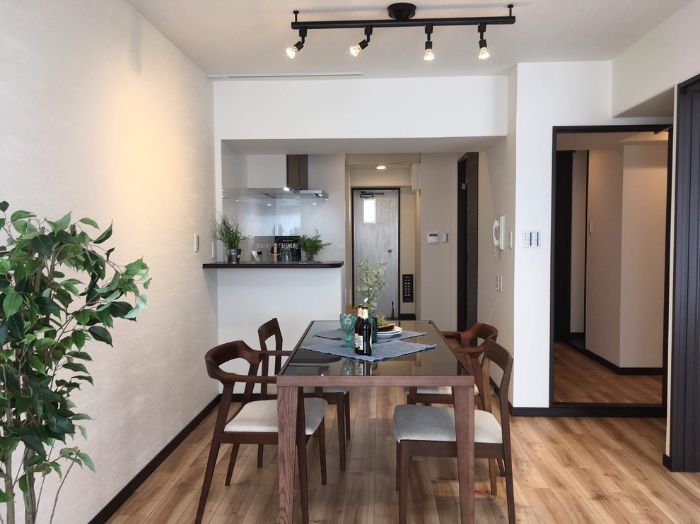 Esempio di una sala da pranzo aperta verso il soggiorno minimalista con pavimento in legno verniciato e pavimento marrone