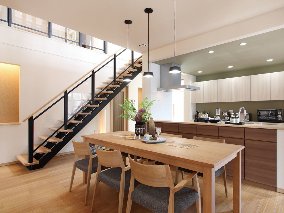 Idee per una sala da pranzo aperta verso il soggiorno con pavimento marrone, pareti bianche e pavimento in compensato