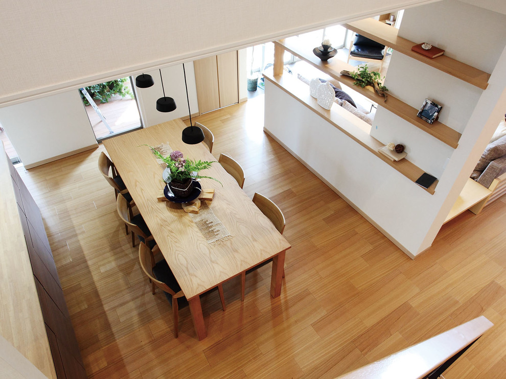 Idee per una sala da pranzo aperta verso il soggiorno con pareti multicolore, pavimento marrone e pavimento in compensato