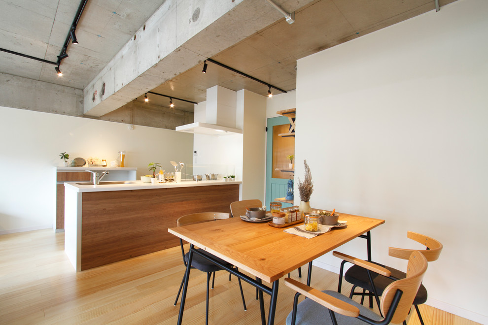 Cette image montre une salle à manger ouverte sur le salon asiatique avec un mur blanc, parquet clair et aucune cheminée.
